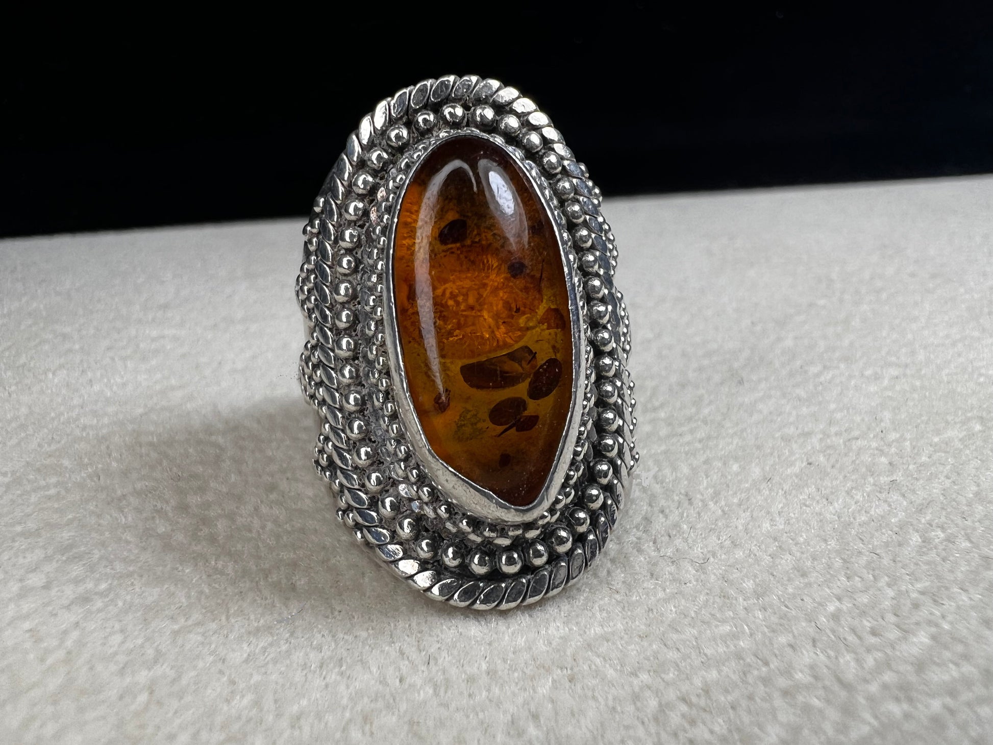 This vintage sterling silver ring features Balinese craftsmanship and a glowing amber cabochon. Made in Indonesia, it blends natural beauty with artisan elegance.