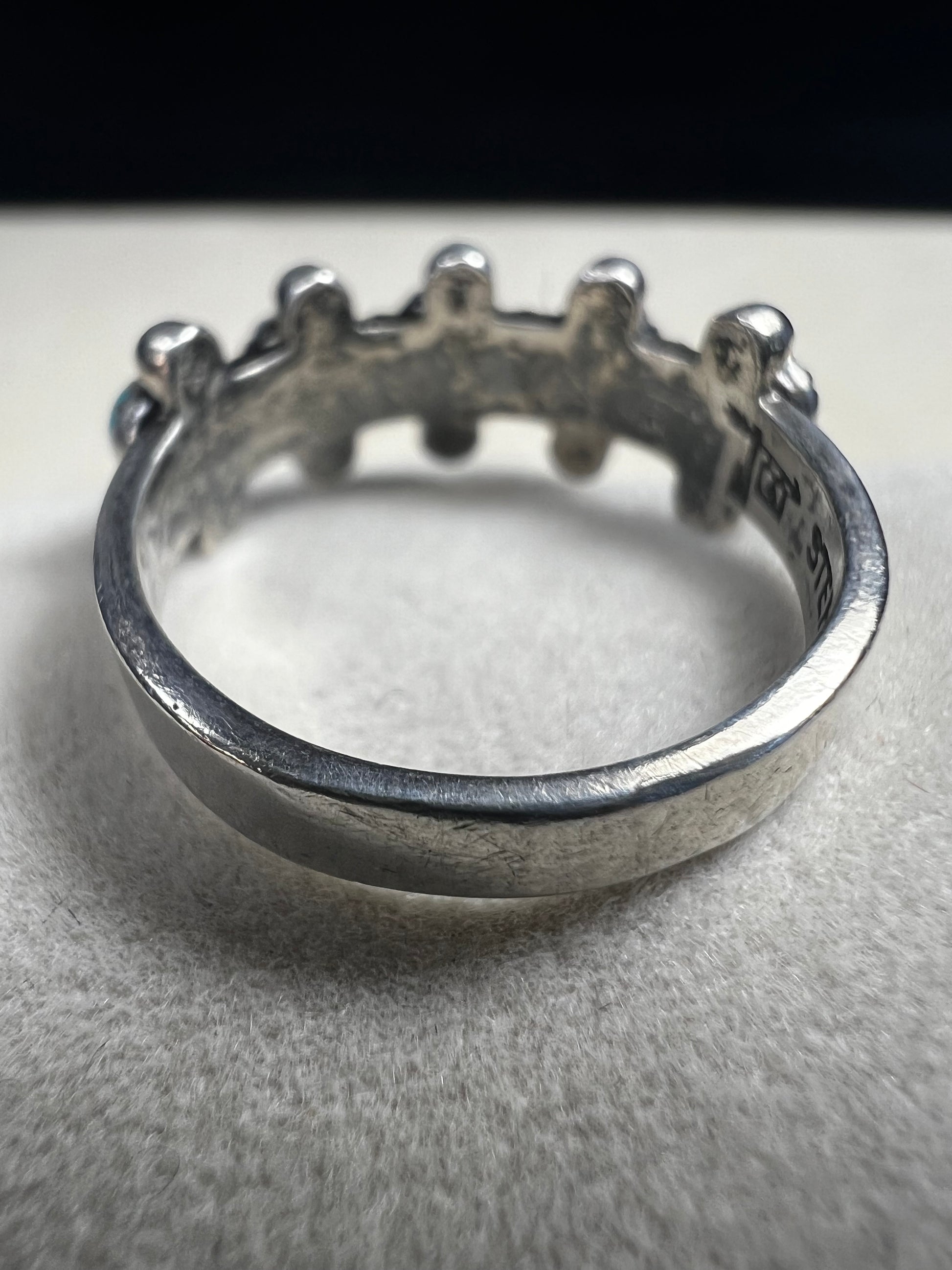 This striking vintage ring features vibrant sky-blue turquoise cabochons set in serrated bezels, accented with bold silver beadwork. Crafted in solid sterling silver, the piece carries the hallmark of Bell Trading Post, a well-known Southwestern jewelry company active from the 1930s through the 1970s.
