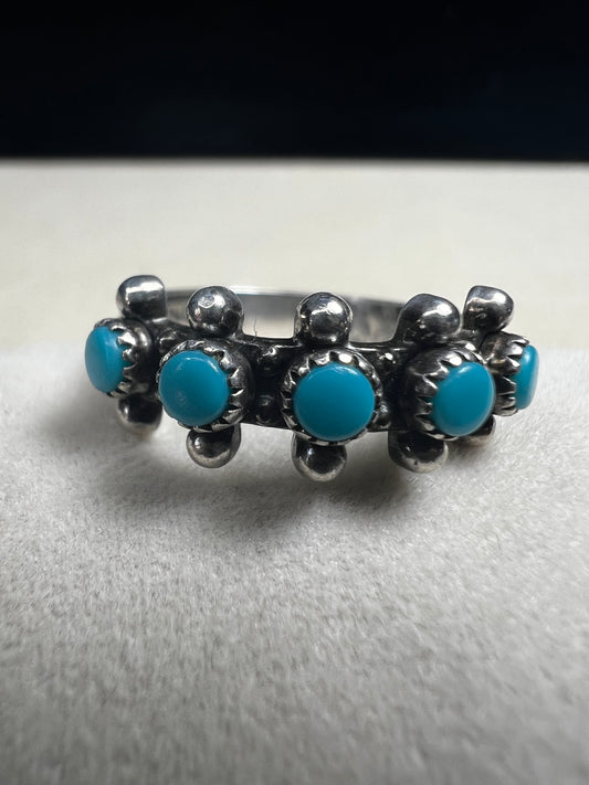 This striking vintage ring features vibrant sky-blue turquoise cabochons set in serrated bezels, accented with bold silver beadwork. Crafted in solid sterling silver, the piece carries the hallmark of Bell Trading Post, a well-known Southwestern jewelry company active from the 1930s through the 1970s.