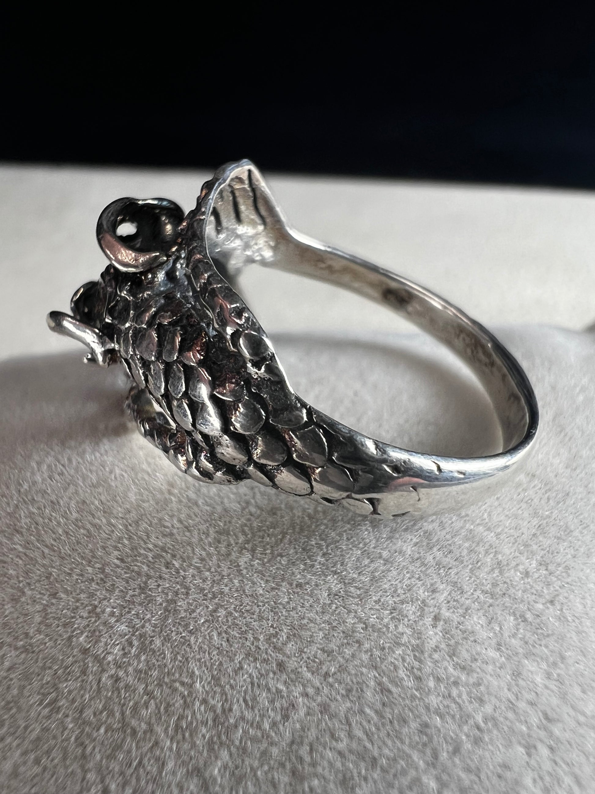 Add a touch of fierce charm to your style with this sterling silver dragon ring. Its detailed design wraps around your finger like a mythical guardian, making it the perfect statement piece.