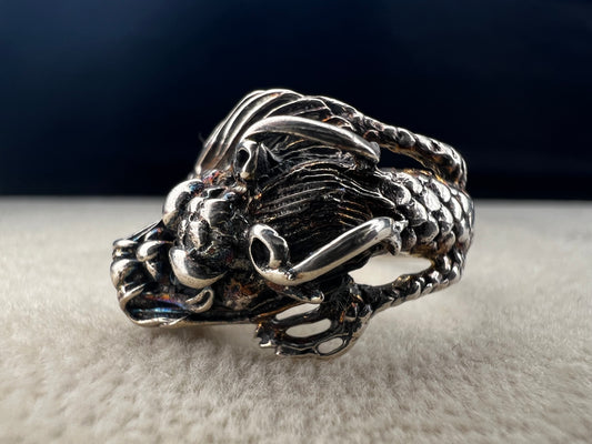 Add a touch of fierce charm to your style with this sterling silver dragon ring. Its detailed design wraps around your finger like a mythical guardian, making it the perfect statement piece.