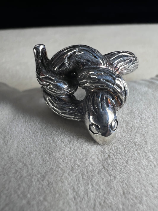 Wrap your finger in mystique with this sterling silver coiled snake ring. Crafted from solid sterling silver, its intricate knotted design adds a playful edge to your look, perfect for those who love a little twist of charm and bold style.