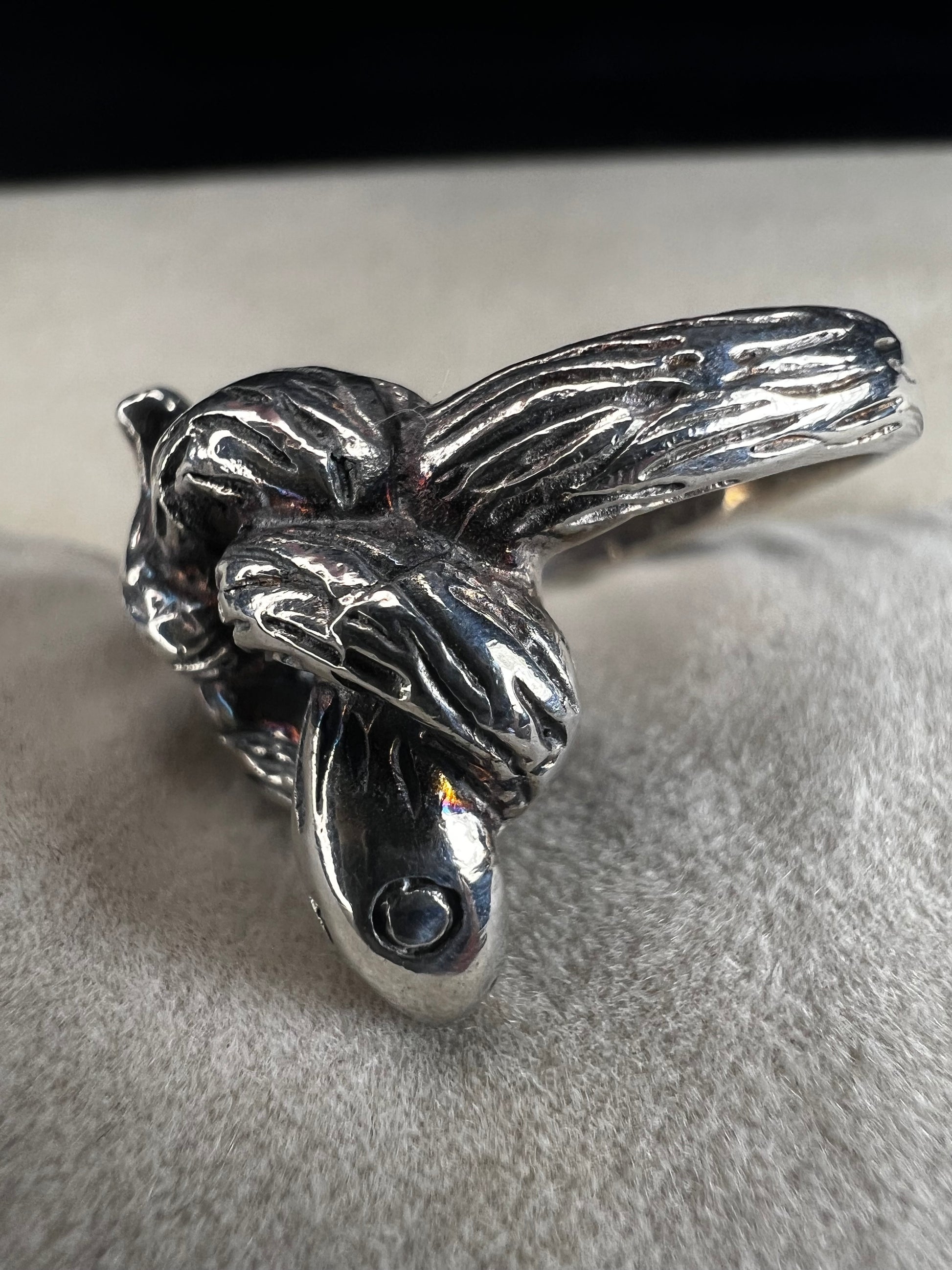 Wrap your finger in mystique with this sterling silver coiled snake ring. Crafted from solid sterling silver, its intricate knotted design adds a playful edge to your look, perfect for those who love a little twist of charm and bold style.