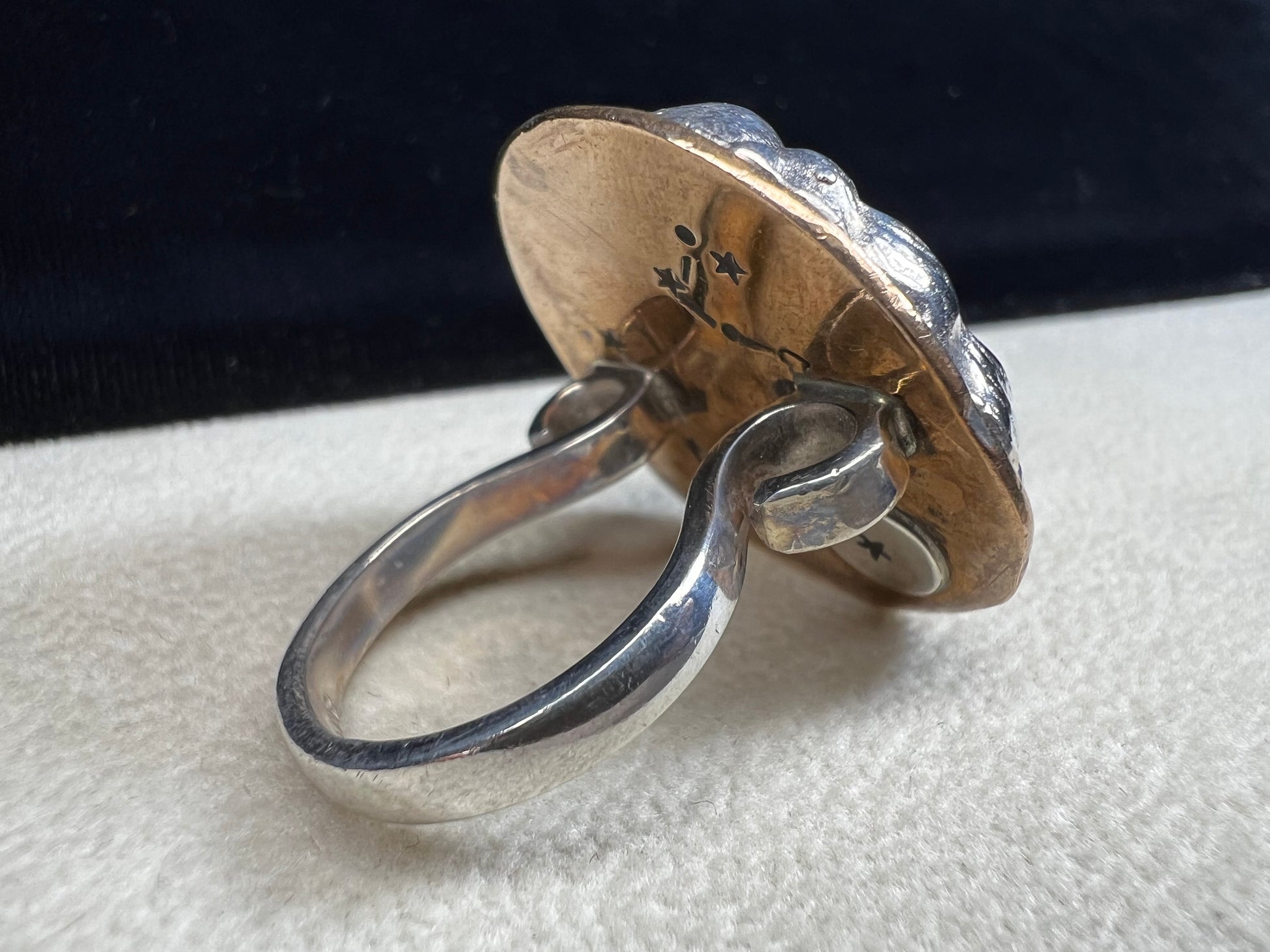 This sterling silver ring by Loving Anvil features a striking lion's head design, expertly crafted for a bold and unique statement. The backing plate is finished in fine gold, adding a stylish two-tone effect.