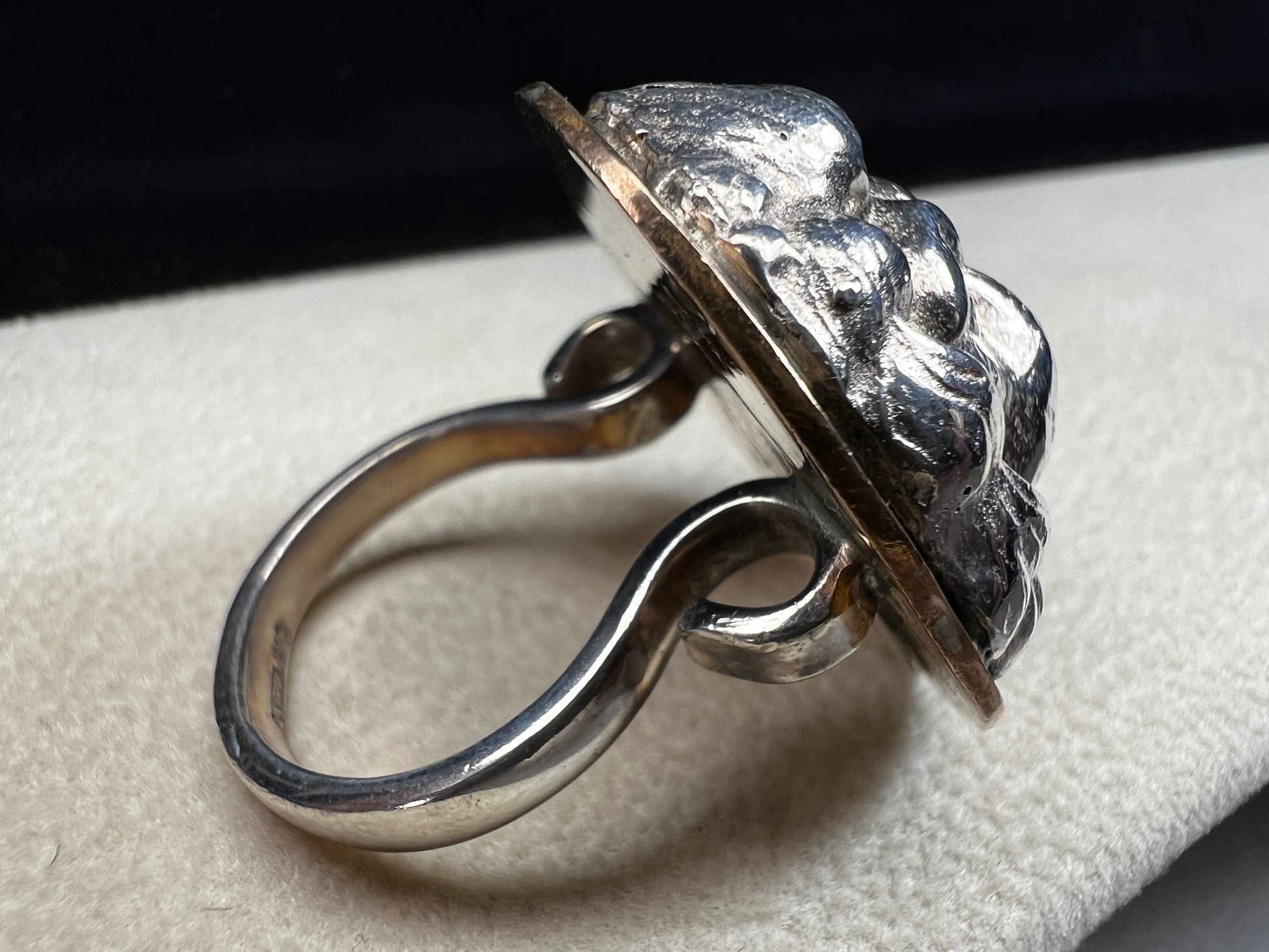 This sterling silver ring by Loving Anvil features a striking lion's head design, expertly crafted for a bold and unique statement. The backing plate is finished in fine gold, adding a stylish two-tone effect.