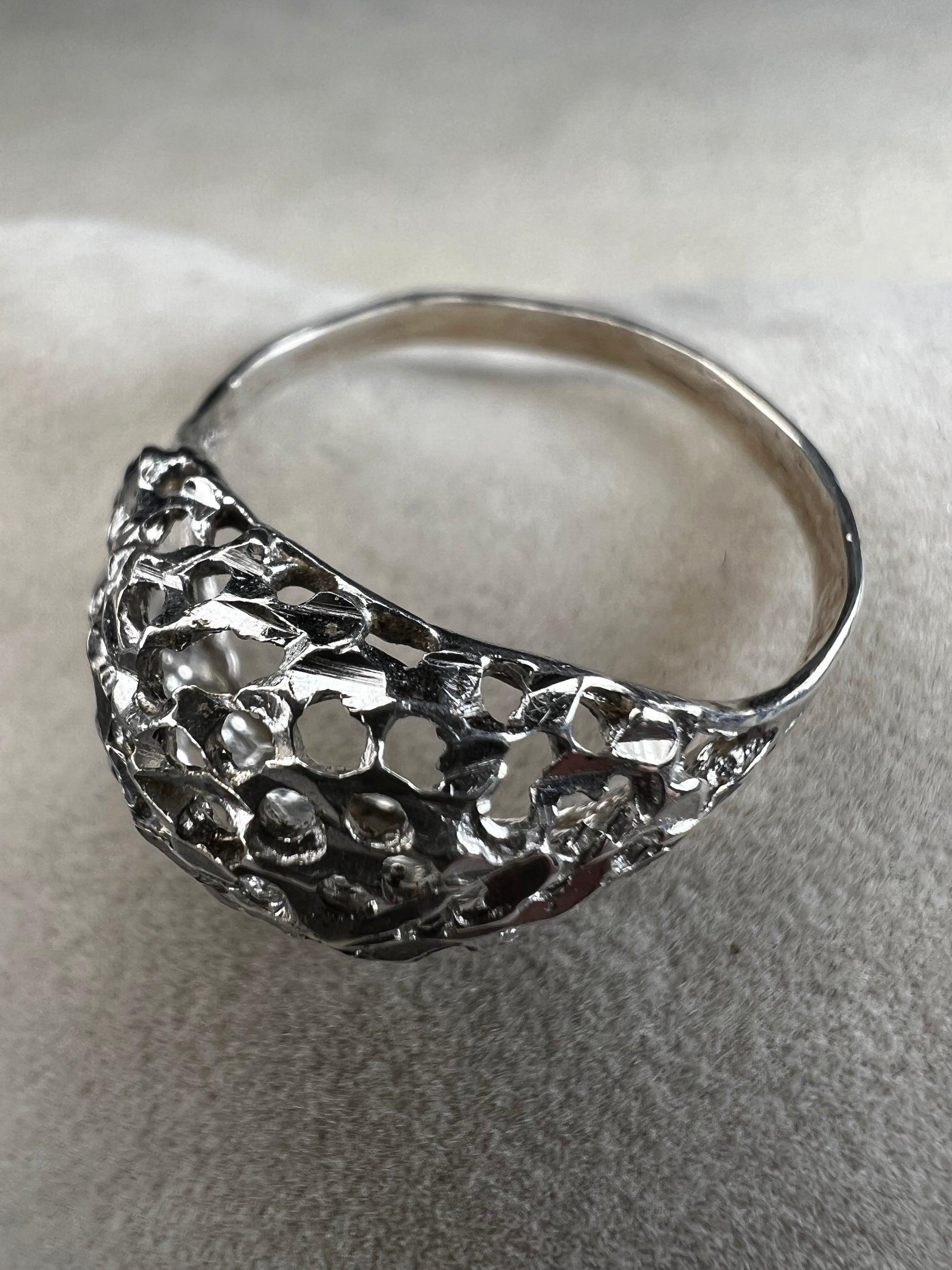 This sterling silver ring features a modern design with diamond-cut detailing that creates the timeless look of a classic nugget ring. Its open work adds elegance and depth, offering a unique style that blends contemporary flair with vintage charm for everyday wear.