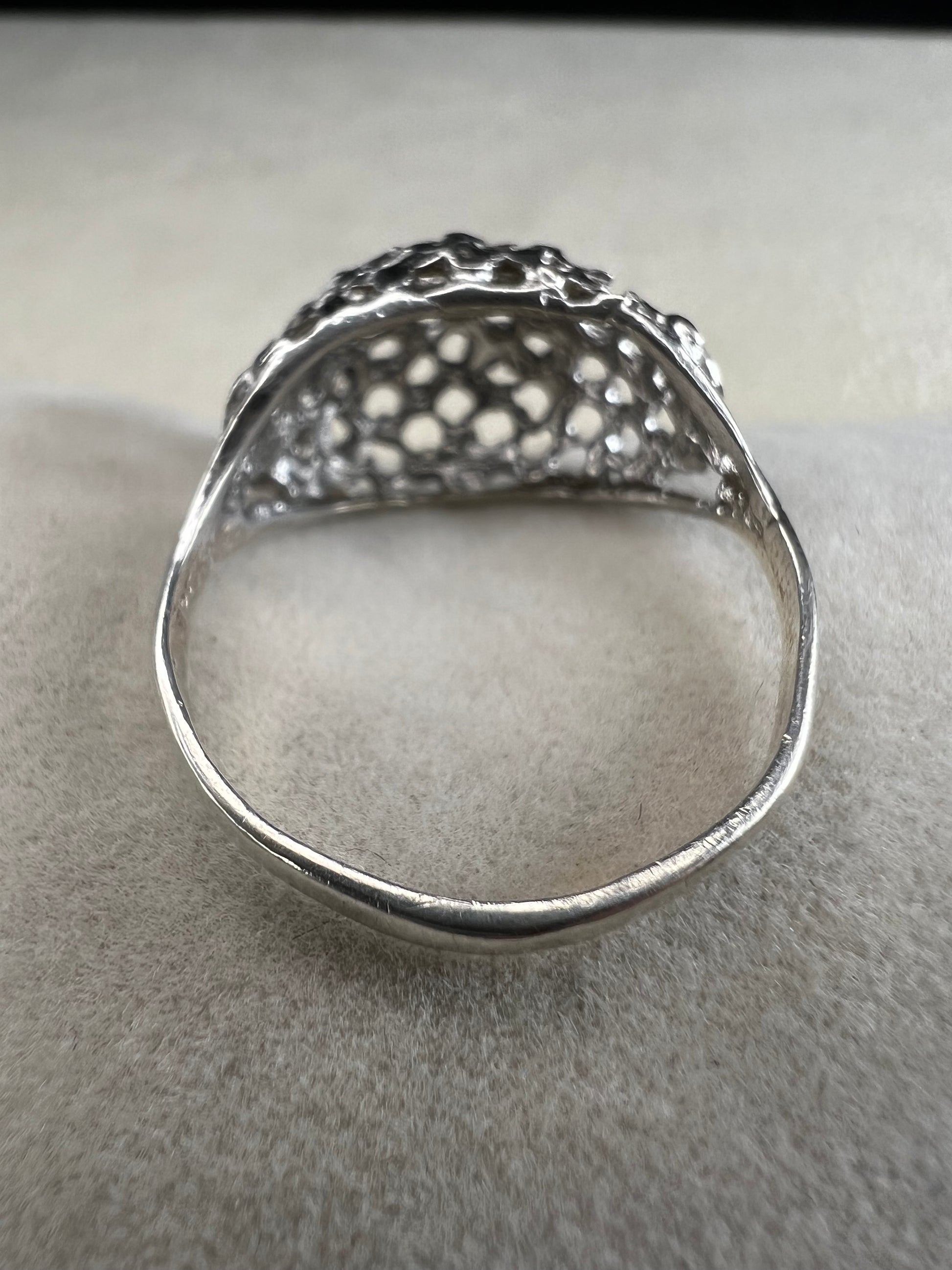 This sterling silver ring features a modern design with diamond-cut detailing that creates the timeless look of a classic nugget ring. Its open work adds elegance and depth, offering a unique style that blends contemporary flair with vintage charm for everyday wear.