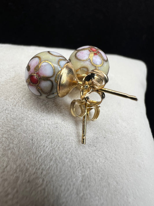 This pair of earrings features an 8 mm cloisonné ball with 14k gold posts and backs. Cloisonné is the art of creating a design on an object by attaching small pieces of wire to a base and filling the compartments with enamel.