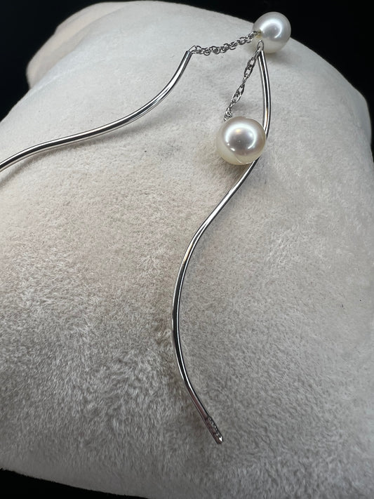 The unique design of these earrings will ensure they will never fall out. Made from 14k white gold, the curved end goes in from the front, leaving a small chain and pearl to drop in front and the curved design to drop in the back.