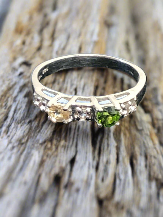 This is a sterling silver ring featuring natural gemstones (green, yellow and white/clear). It's a nice look for everyday wear or for special occasions.