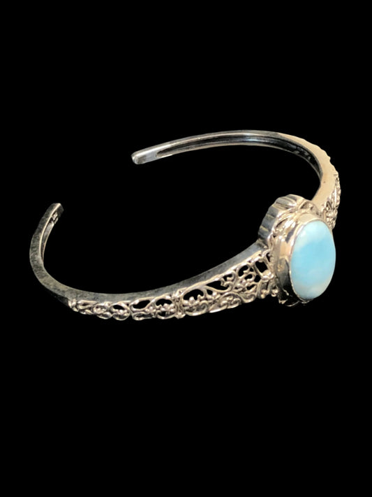 This sterling silver cuff bracelet boasts a beautiful oval chalcedony stone. It is surrounded by a classy filigree setting and band.