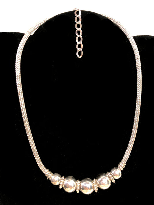 Get ready to make a statement with this sterling silver necklace. Adorned with a cluster of beads (also sterling silver) front and center, this piece will complement a variety of looks.
