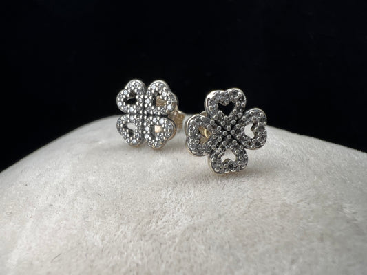 These are beautiful sterling silver earrings. They are shaped as four-leaf clovers with heart designs in each leaf and set with small clear stones throughout.