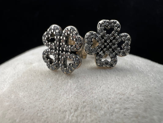 These are beautiful sterling silver earrings. They are shaped as four-leaf clovers with heart designs in each leaf and set with small clear stones throughout.
