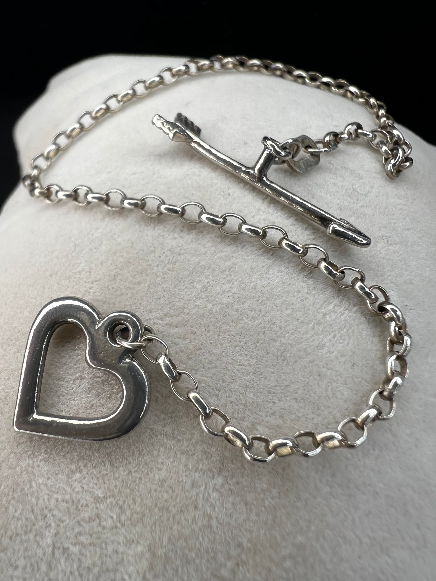 This is a petite, lovely sterling silver bracelet. The arrow goes through the heart, creating a secure closure.