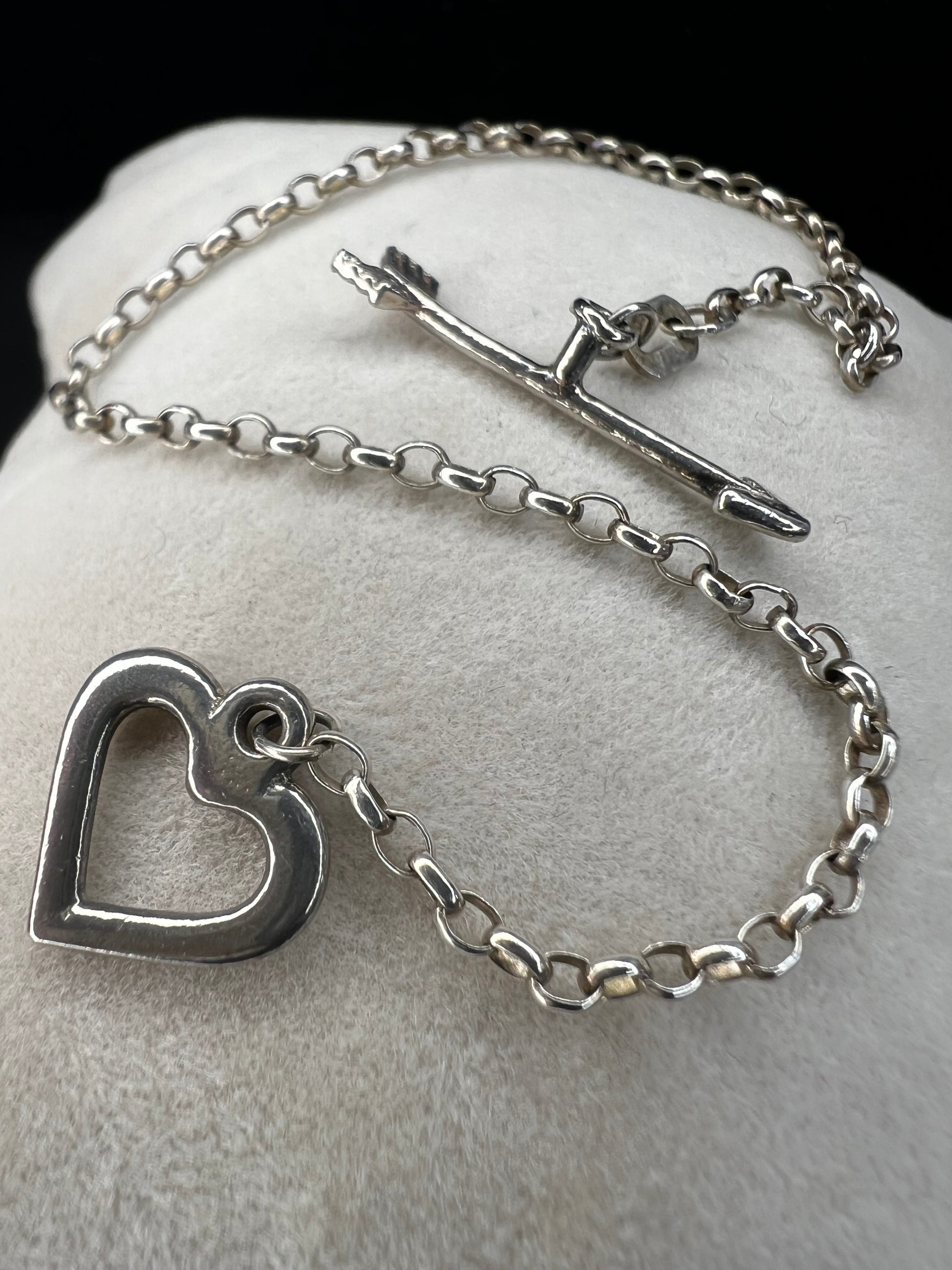 This is a petite, lovely sterling silver bracelet. The arrow goes through the heart, creating a secure closure.