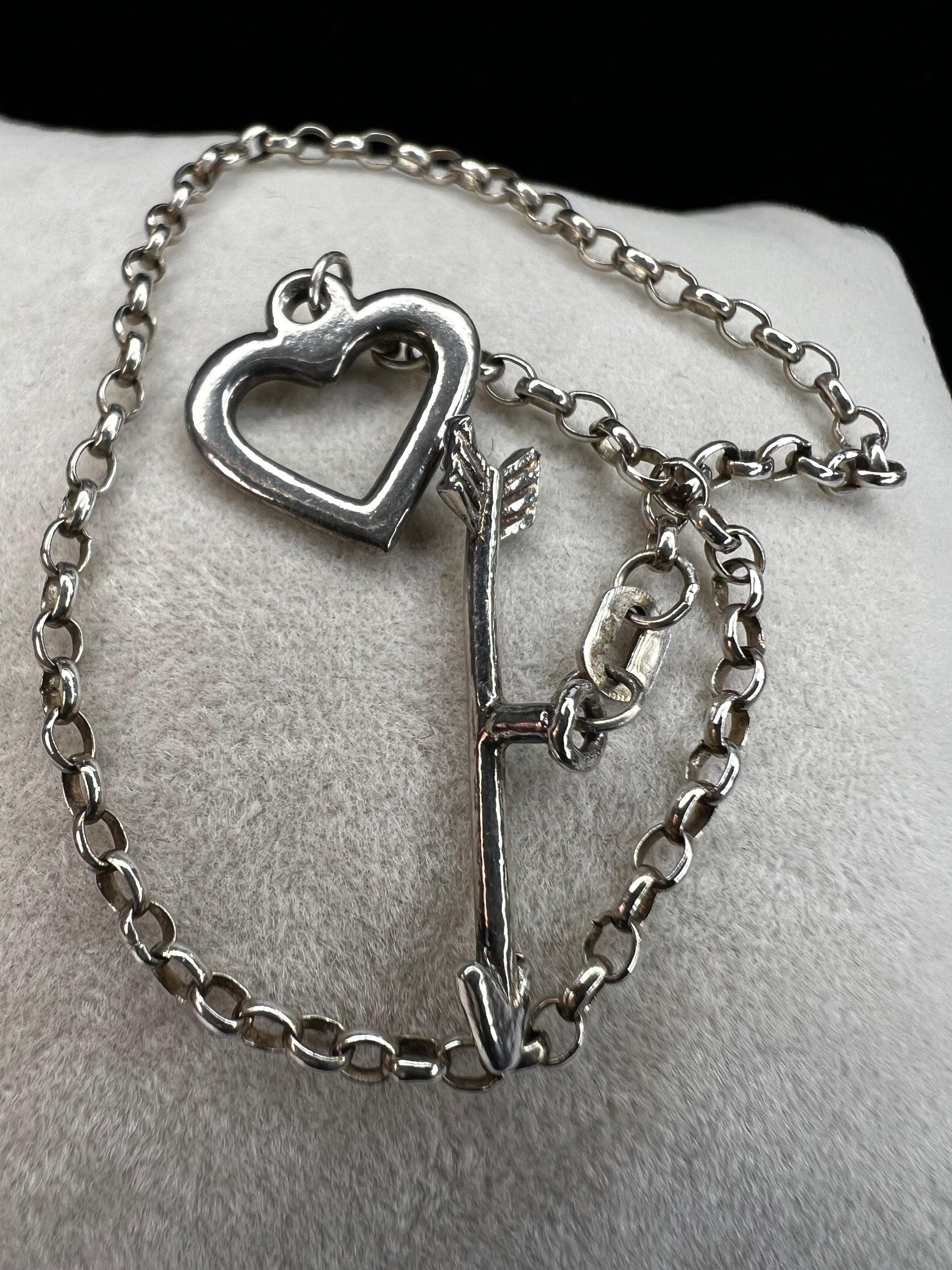This is a petite, lovely sterling silver bracelet. The arrow goes through the heart, creating a secure closure.