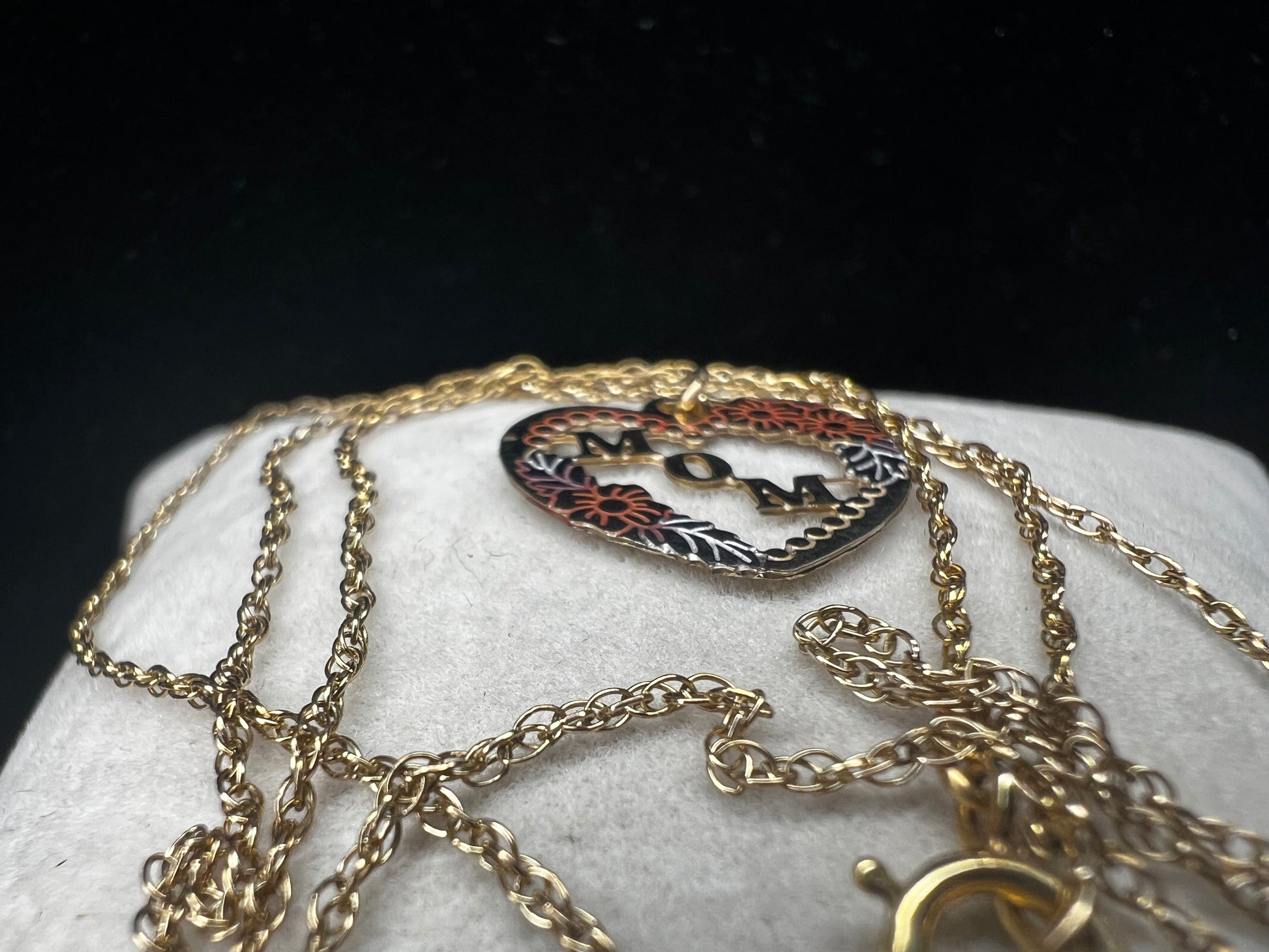 Show your mom some love with our 14 karat gold filled chain necklace and heart pendant. The chain features sturdy links with a delicate look, and the pendant has a touch of color through some enamel on the flower and silver leaves.