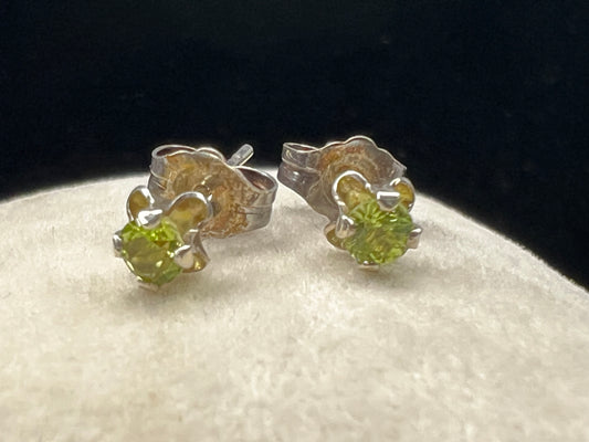 These delicate stud earrings feature sterling silver paired with small natural green stones, offering a subtle yet refreshing splash of color. Their elegant design makes them perfect for everyday wear.