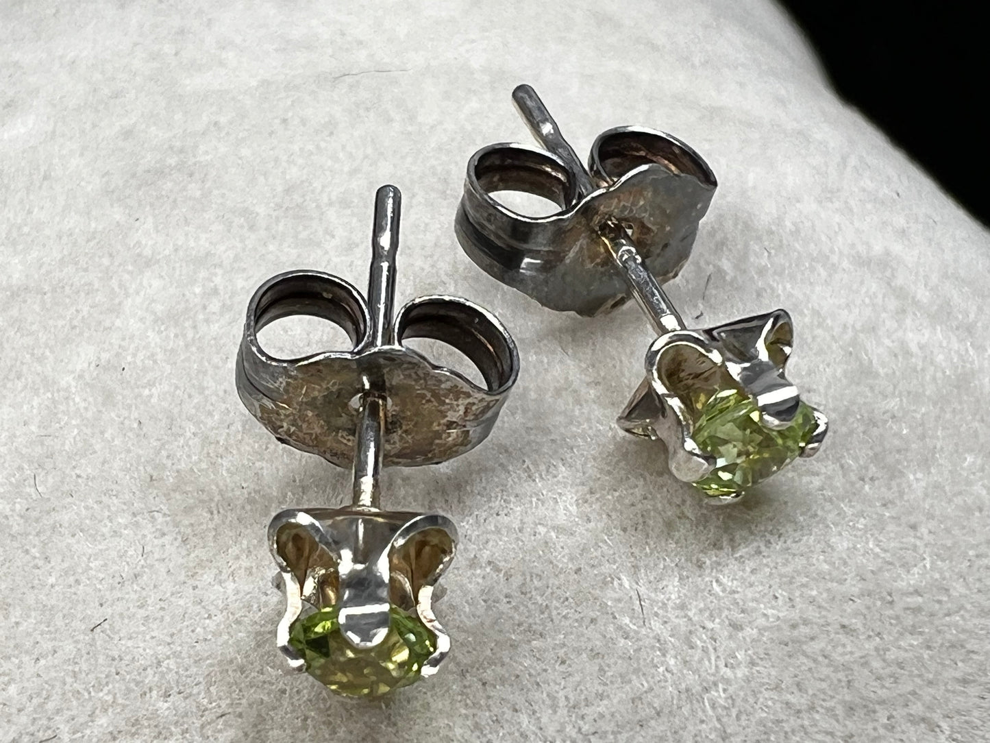 These delicate stud earrings feature sterling silver paired with small natural green stones, offering a subtle yet refreshing splash of color. Their elegant design makes them perfect for everyday wear.