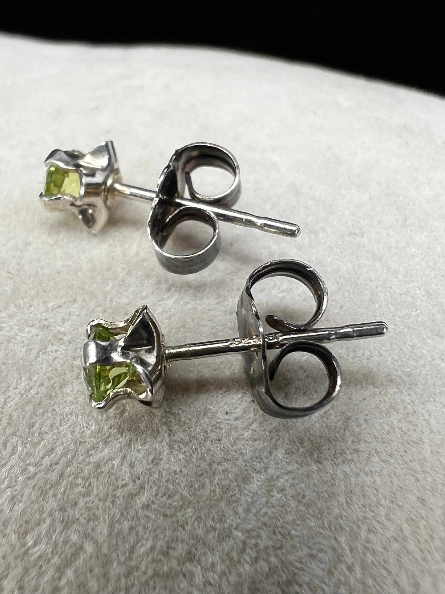 These delicate stud earrings feature sterling silver paired with small natural green stones, offering a subtle yet refreshing splash of color. Their elegant design makes them perfect for everyday wear.