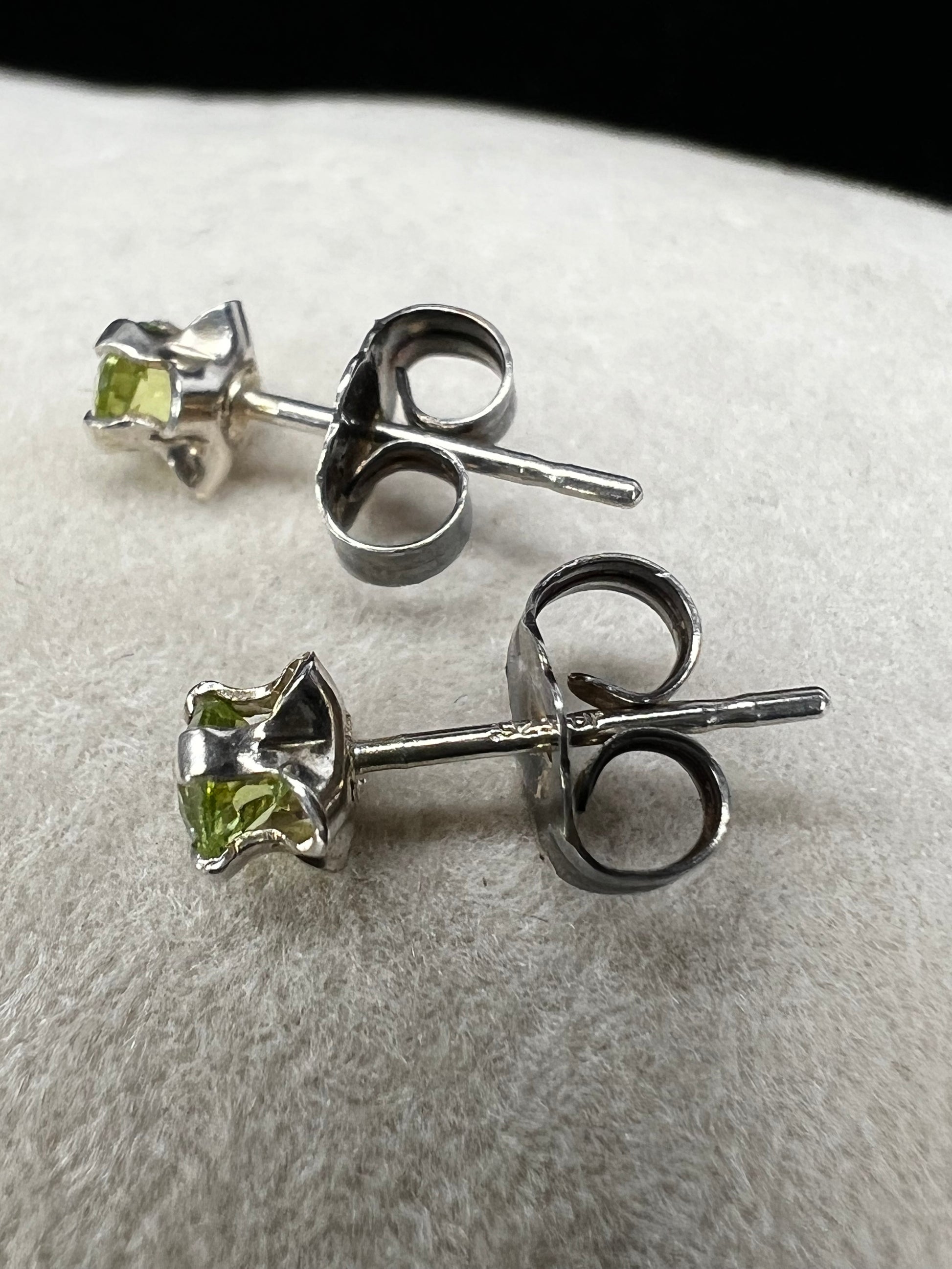 These delicate stud earrings feature sterling silver paired with small natural green stones, offering a subtle yet refreshing splash of color. Their elegant design makes them perfect for everyday wear.