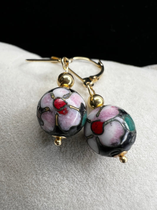 This is a beautiful pair of earrings. They feature cloisonné beads with pink flowers and green leaves set against a black back background to make the flowers pop. Marked 585 (another term for 14 karat gold).