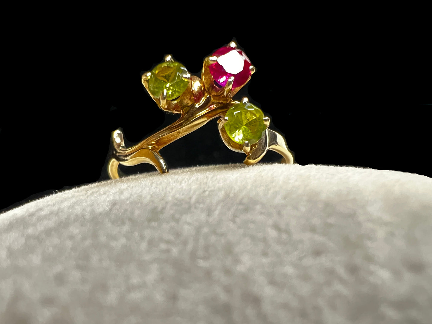 Crafted from 10 karat gold and designed to look like a tree branch, this ring is set with two spinels and a ruby.