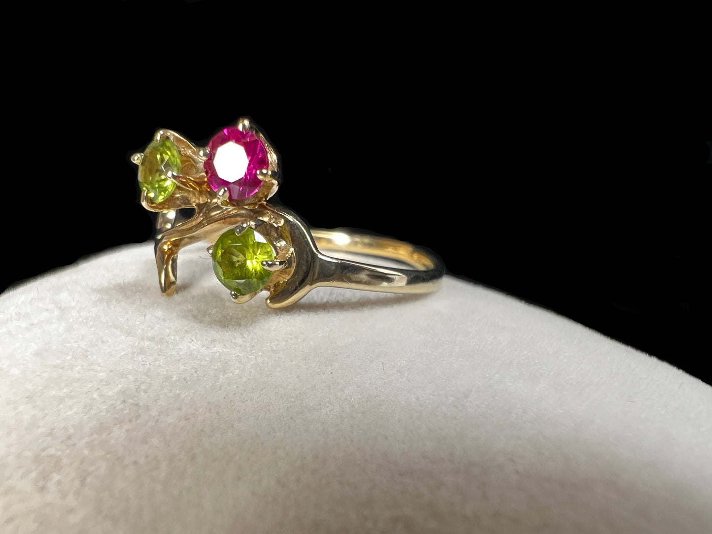 Crafted from 10 karat gold and designed to look like a tree branch, this ring is set with two spinels and a ruby.