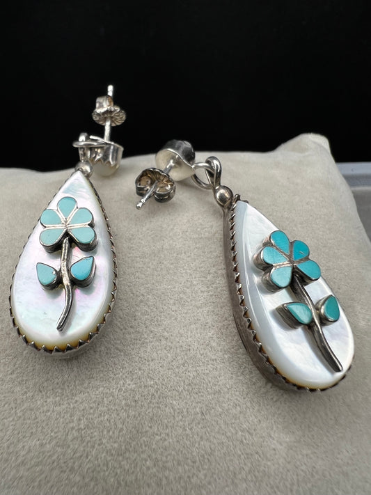 These handmade Zuni sterling silver earrings feature raised turquoise flowers set over luminous mother of pearl. Signed CL Zuni, these teardrop earrings showcase traditional Native American artistry with beautiful depth and dimension.