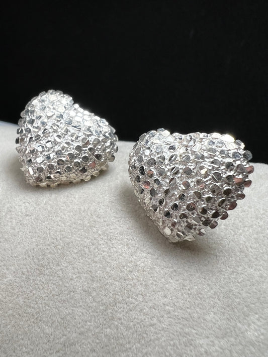 These bold heart-shaped sterling silver earrings are designed to look like a cluster of diamonds. It's a stunning look that will catch the light from every angle.