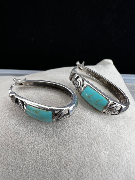 These vintage sterling silver earrings feature an openwork design accented with turquoise stones, offering a timeless vintage look.