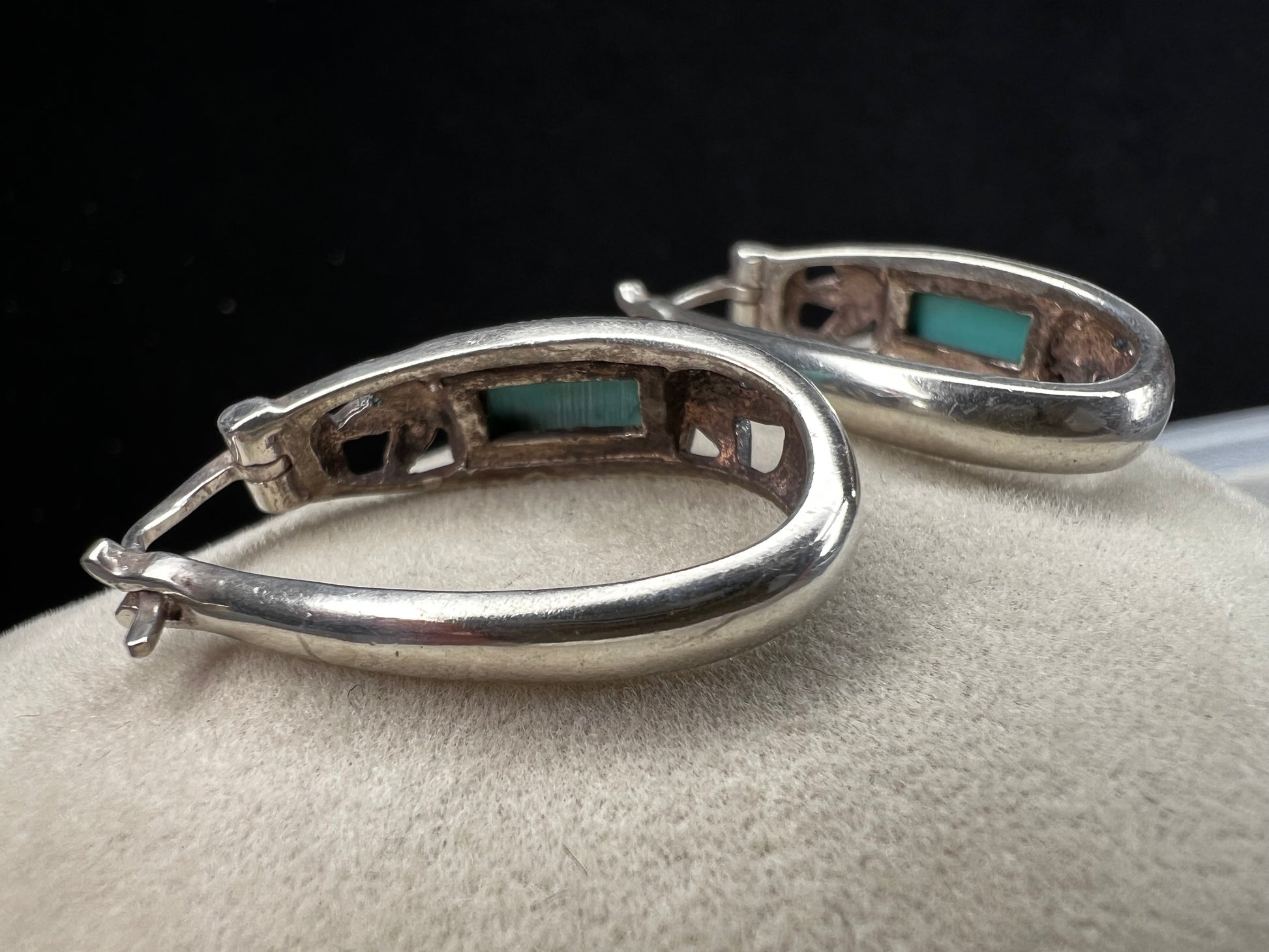 These vintage sterling silver earrings feature an openwork design accented with turquoise stones, offering a timeless vintage look.