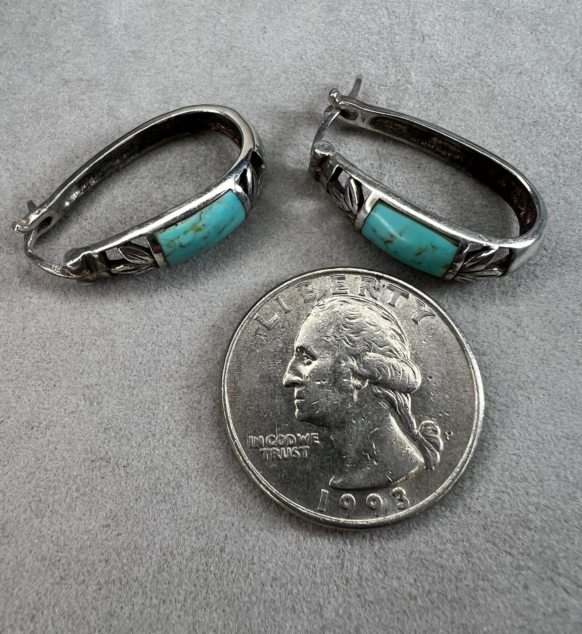 These vintage sterling silver earrings feature an openwork design accented with turquoise stones, offering a timeless vintage look.