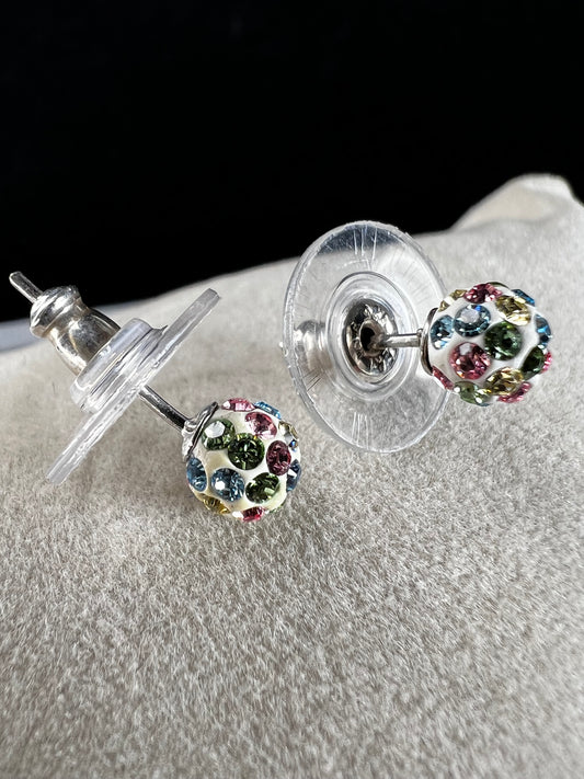Crafted from sterling silver, these stud earrings are detailed with white enamel and sprinkled with crystals in a variety of colors that create a vibrant sparkle.