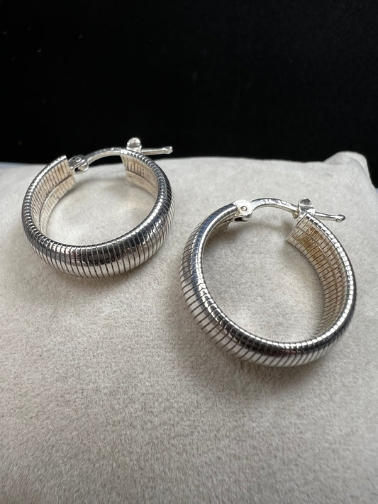 These sterling silver earrings feature a bold, domed design accented by horizontal ridges that catch the light beautifully.