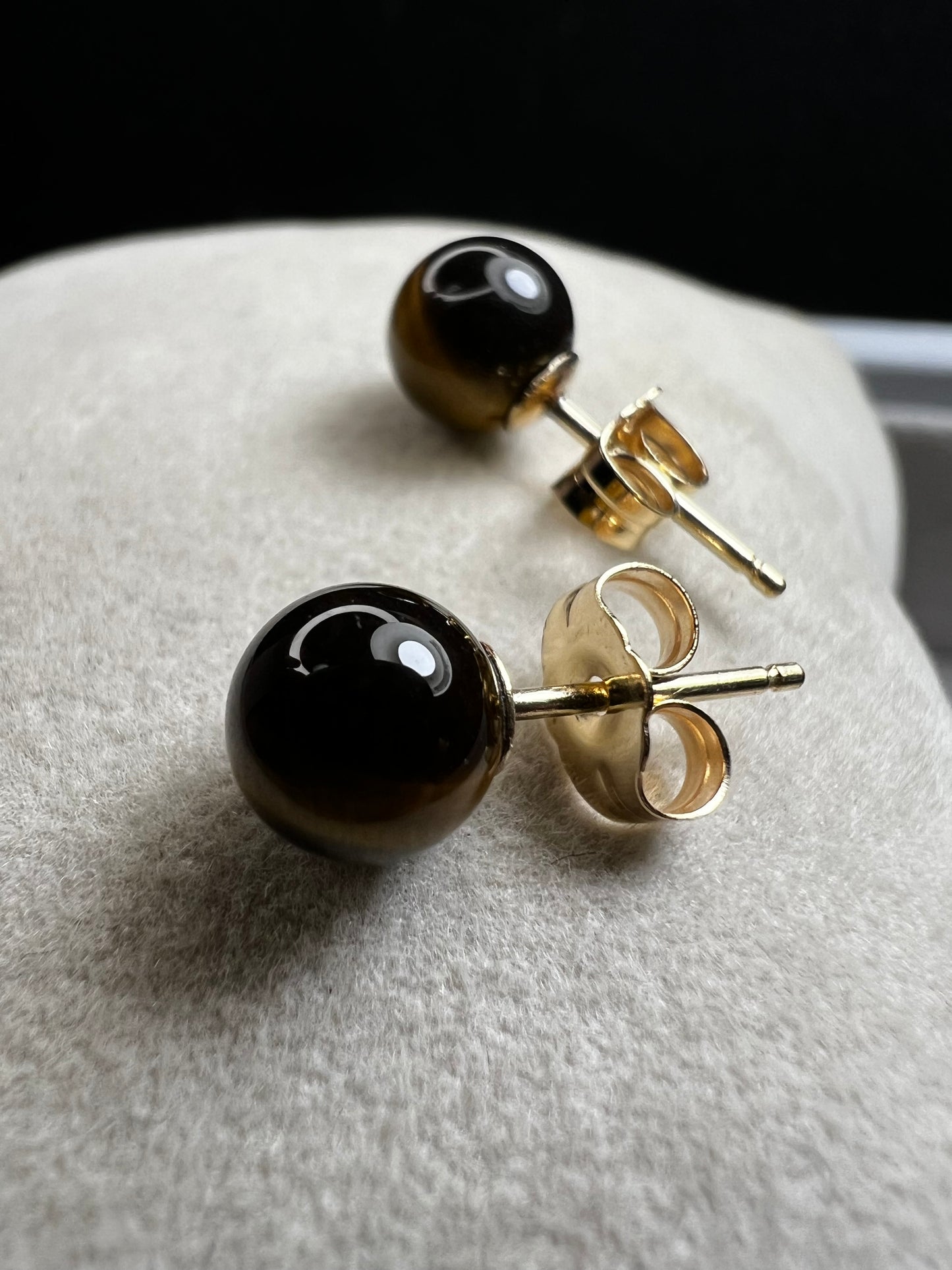 These earrings are crafted with 14 karat gold and feature a beautiful, petite tiger's eye stone.