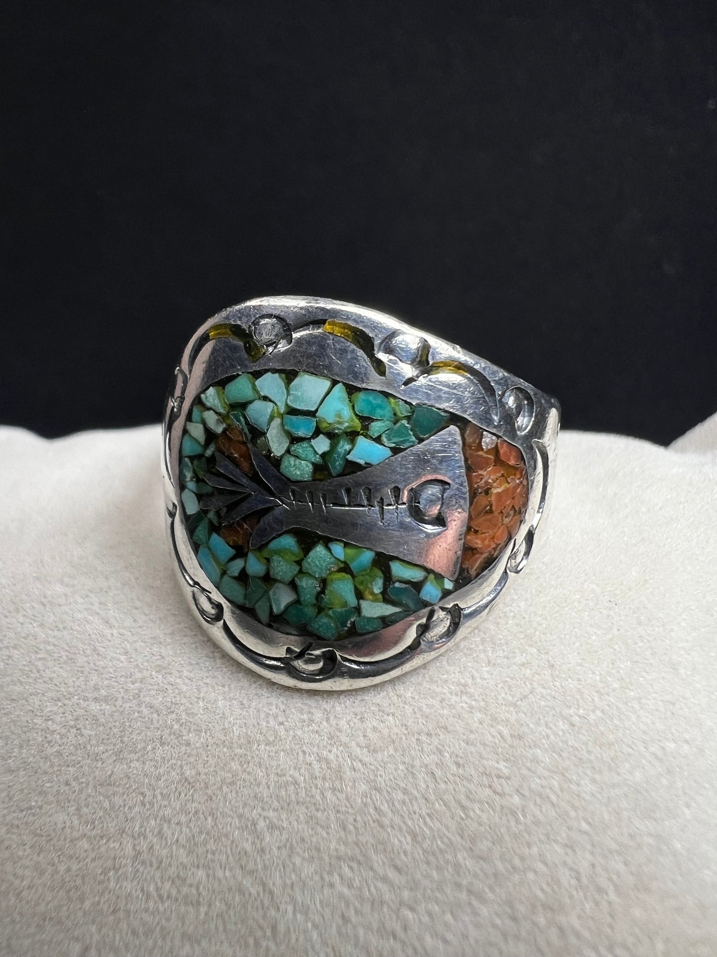 This expertly crafted vintage sterling silver ring, signed LB, showcases intricate detailing that captures timeless elegance. Accented with turquoise chips, it offers a distinctive and striking look, perfect for collectors or anyone seeking a unique piece with authentic vintage charm.