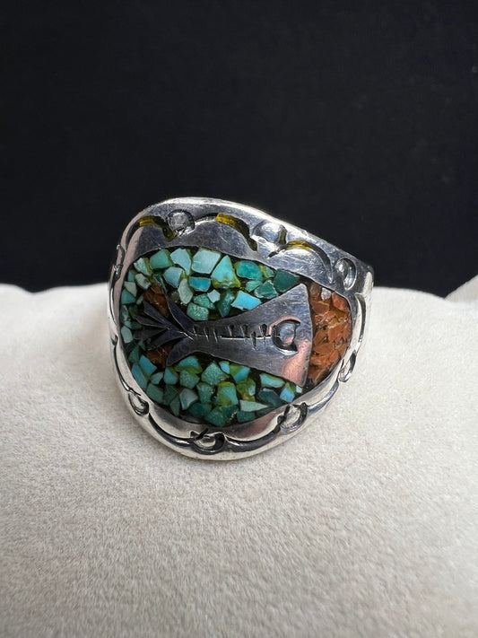 This expertly crafted vintage sterling silver ring, signed LB, showcases intricate detailing that captures timeless elegance. Accented with turquoise chips, it offers a distinctive and striking look, perfect for collectors or anyone seeking a unique piece with authentic vintage charm.