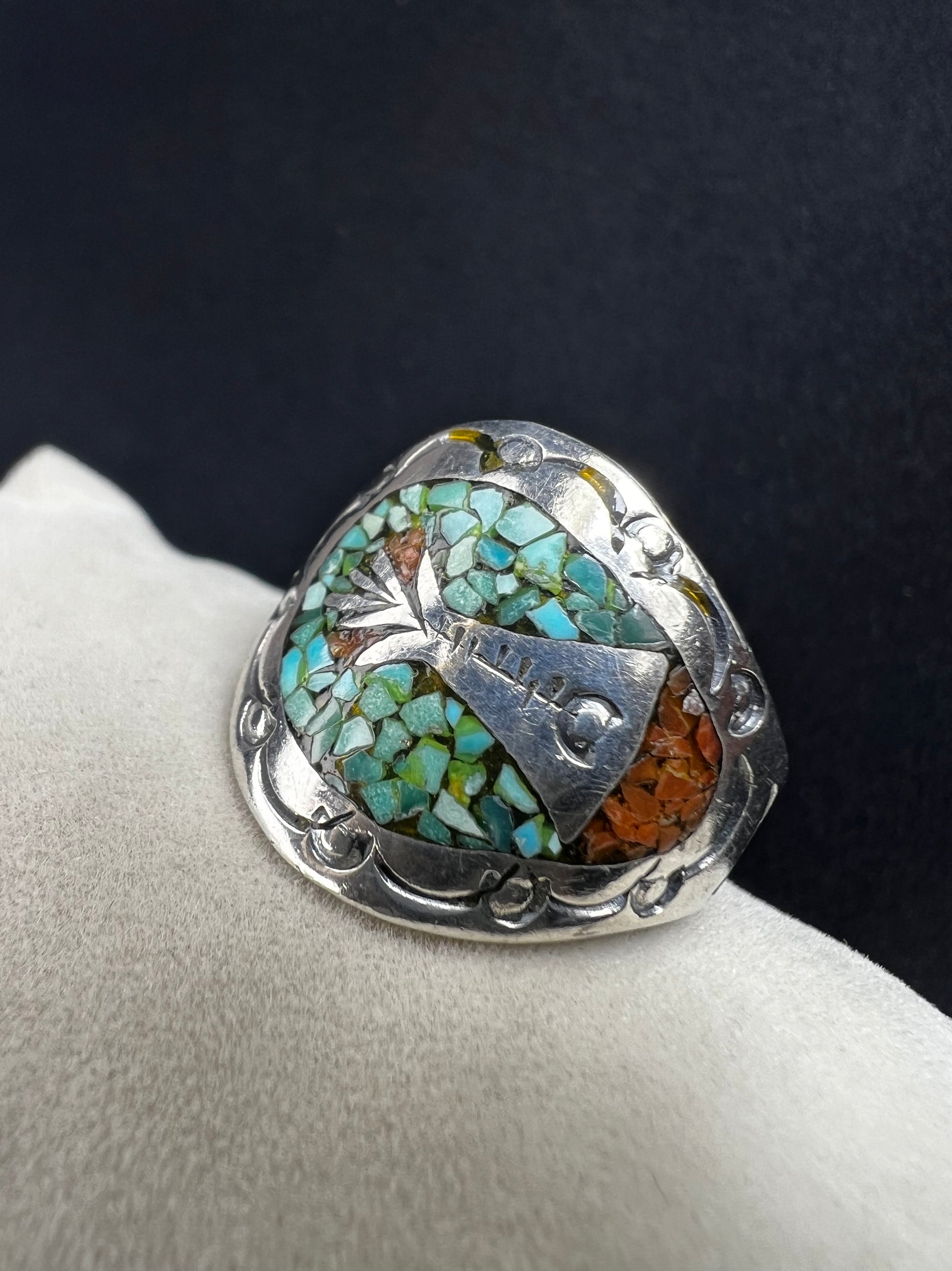 This expertly crafted vintage sterling silver ring, signed LB, showcases intricate detailing that captures timeless elegance. Accented with turquoise chips, it offers a distinctive and striking look, perfect for collectors or anyone seeking a unique piece with authentic vintage charm.