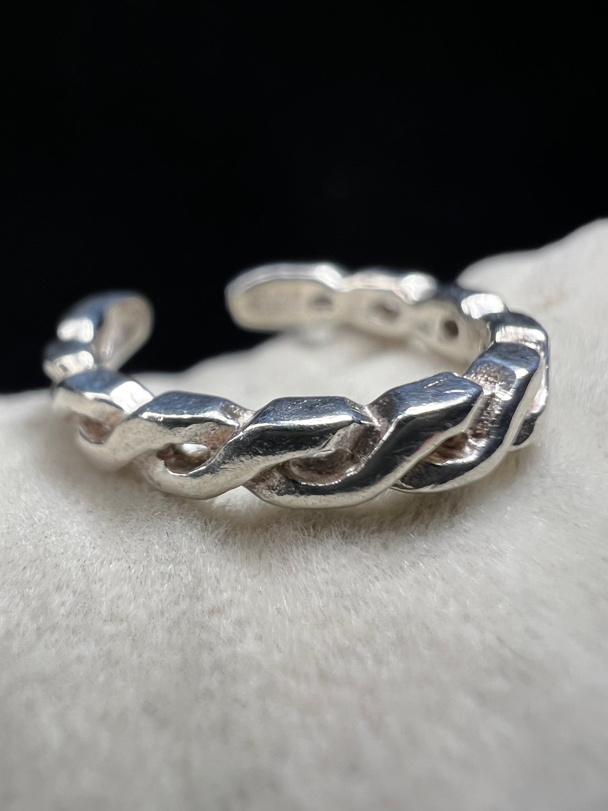 This braided sterling silver toe ring features a contemporary twisted design, ideal for adding a stylish touch to your look at the beach or pool.