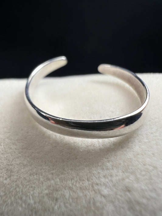 This sterling silver open band toe ring offers a simple, elegant design that adds a subtle shine to your foot, perfect for wearing at the beach or poolside. Its minimalist style ensures versatile wear while providing a touch of refined sparkle.