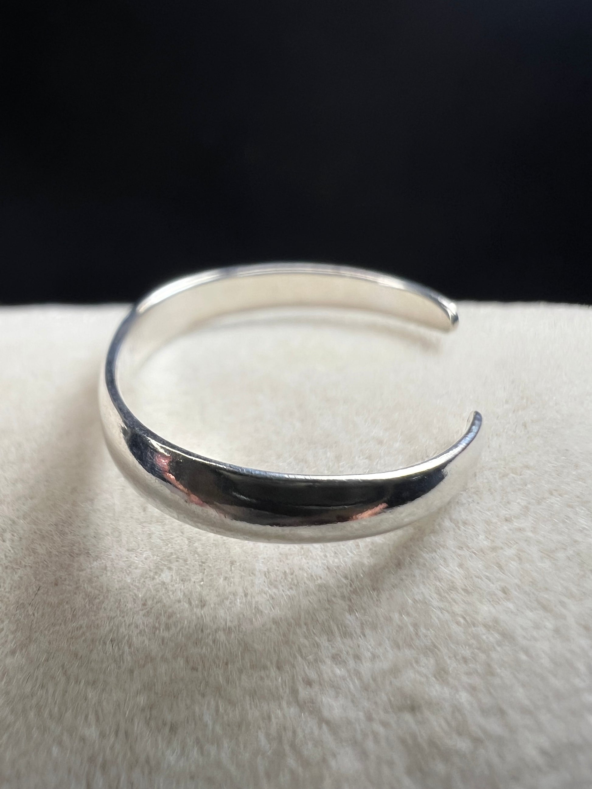 This sterling silver open band toe ring offers a simple, elegant design that adds a subtle shine to your foot, perfect for wearing at the beach or poolside. Its minimalist style ensures versatile wear while providing a touch of refined sparkle.