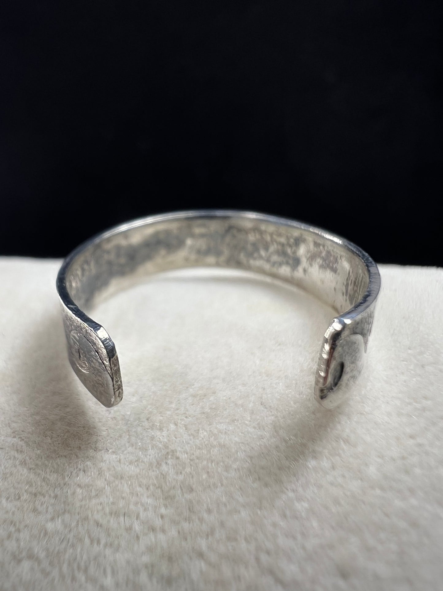 This vintage sterling silver toe ring features an open band with a timeless wave design, ideal for beach enthusiasts. Its detailed craftsmanship captures the effortless spirit of the ocean, making it a refined accessory for seaside or casual wear.