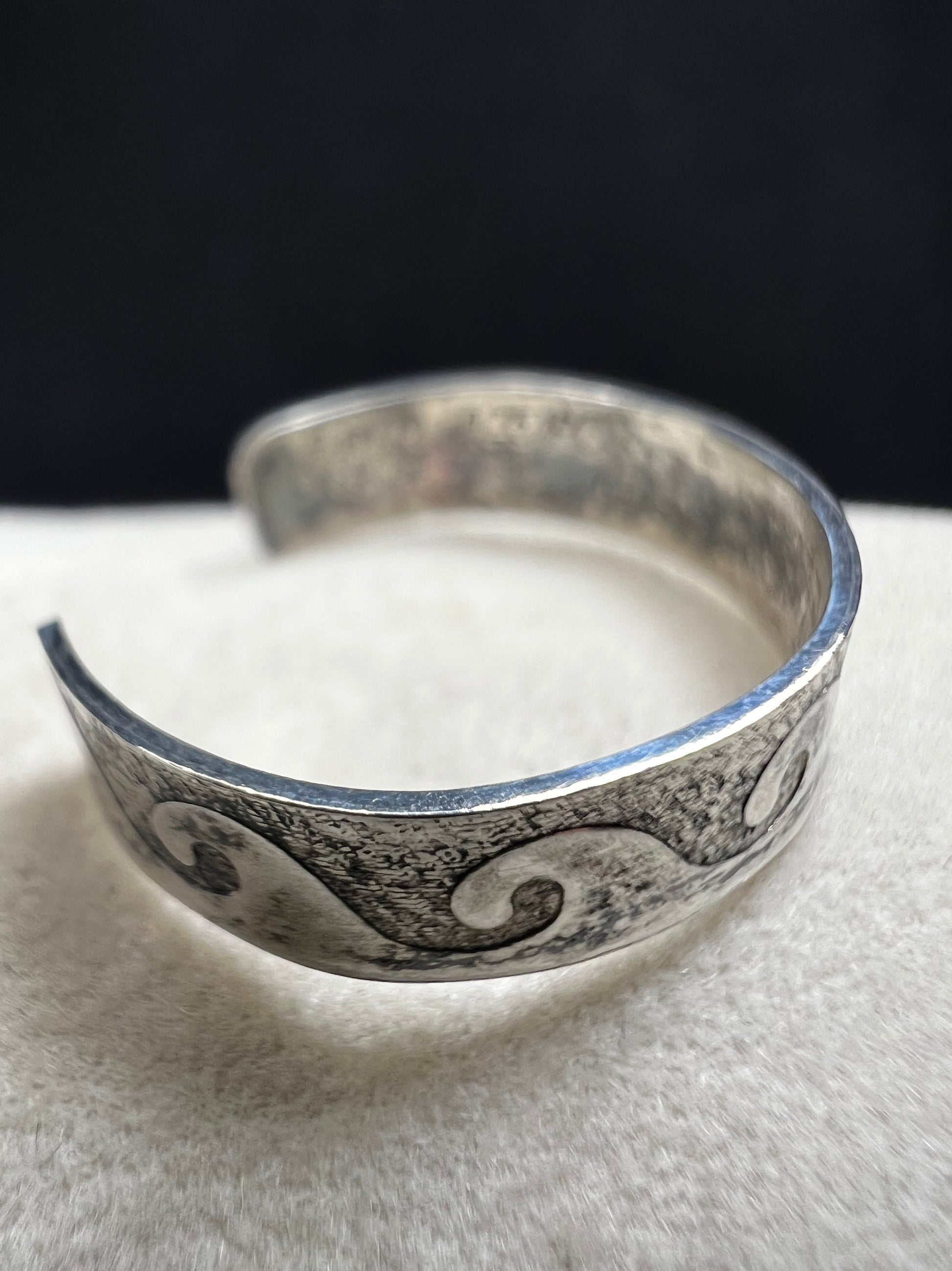 This vintage sterling silver toe ring features an open band with a timeless wave design, ideal for beach enthusiasts. Its detailed craftsmanship captures the effortless spirit of the ocean, making it a refined accessory for seaside or casual wear.