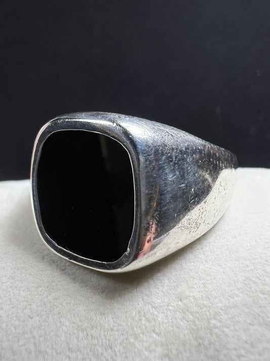 This vintage Avon ring combines sterling silver craftsmanship with a bold onyx centerpiece, designed to make a distinctive statement. Sized at 12.5, its unisex design suits both men and women seeking a timeless accessory with elegant presence.