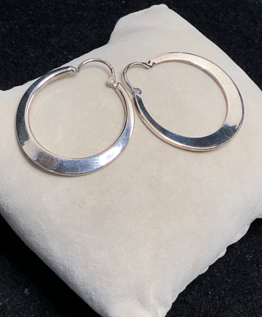 These 1 1/4" sterling silver hoop earrings are crafted with solid construction to ensure durability and lasting wear. Their timeless design offers a versatile accessory that complements any outfit.
