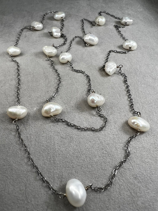 This 34-inch sterling silver chain is accented with baroque pearls spaced a few inches apart. Designed without a clasp, it slips easily over your head for effortless wear.