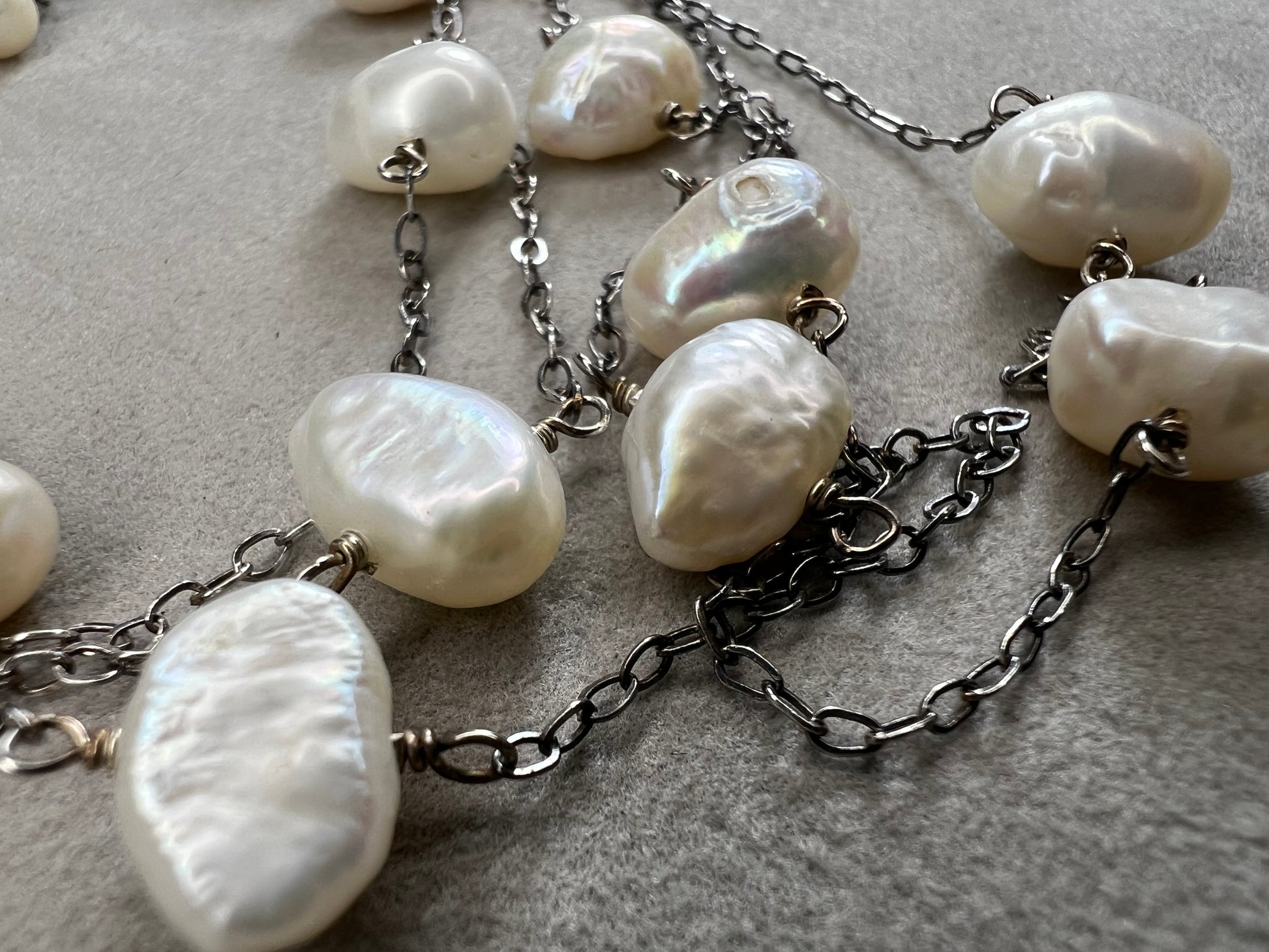 This 34-inch sterling silver chain is accented with baroque pearls spaced a few inches apart. Designed without a clasp, it slips easily over your head for effortless wear.