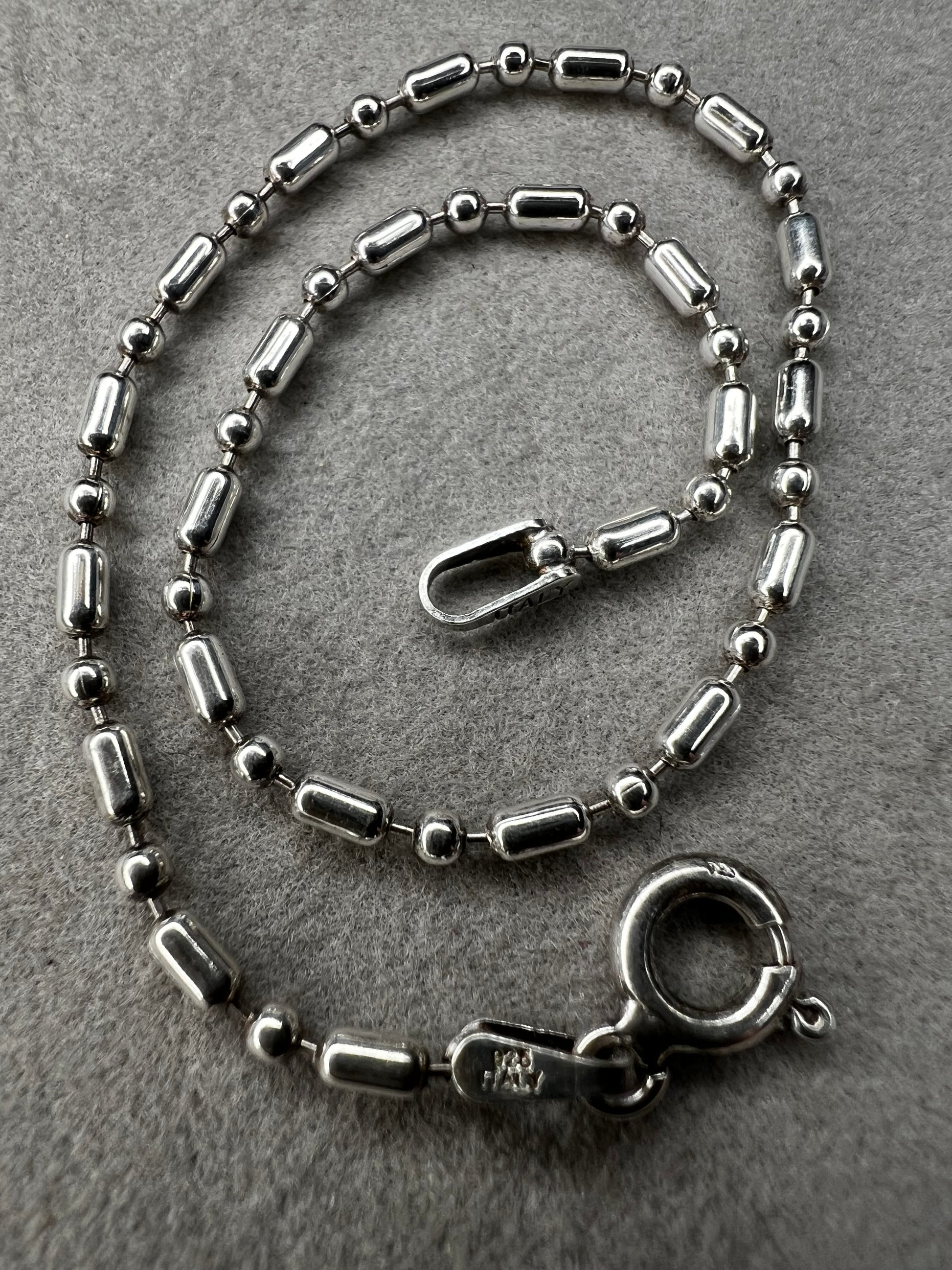 This sterling silver bracelet features an expertly crafted bead-and-tube link design, offering a distinctive alternative to traditional chains.
